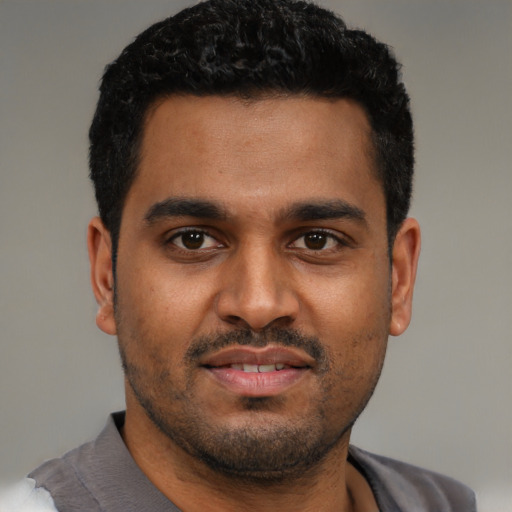 Joyful black young-adult male with short  black hair and brown eyes