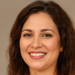 Joyful white adult female with long  brown hair and brown eyes