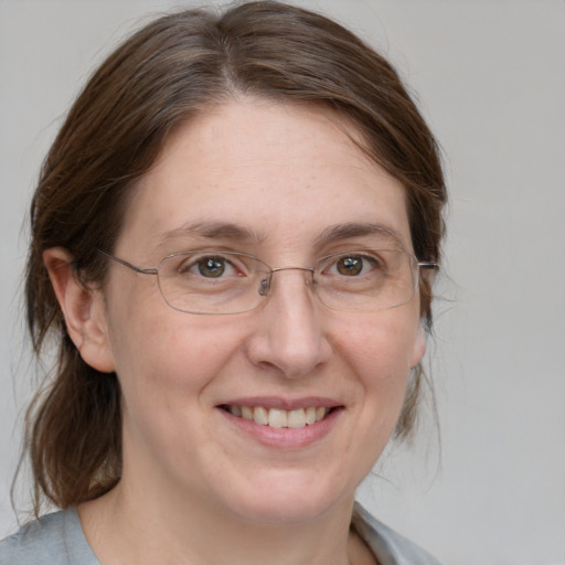 Joyful white adult female with medium  brown hair and grey eyes