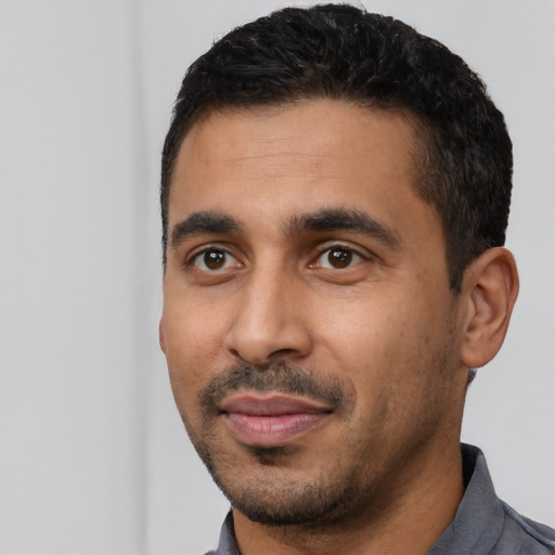 Joyful latino young-adult male with short  black hair and brown eyes