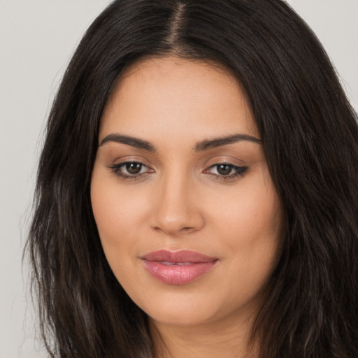 Joyful latino young-adult female with long  brown hair and brown eyes