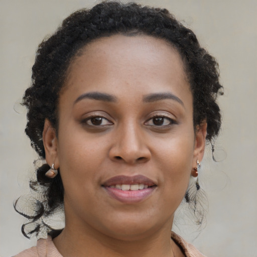 Joyful black young-adult female with long  brown hair and brown eyes