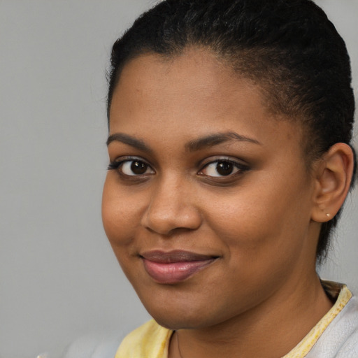 Joyful black young-adult female with short  brown hair and brown eyes