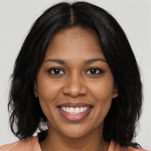 Joyful black young-adult female with long  black hair and brown eyes