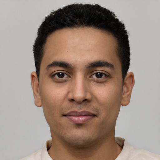 Joyful latino young-adult male with short  black hair and brown eyes