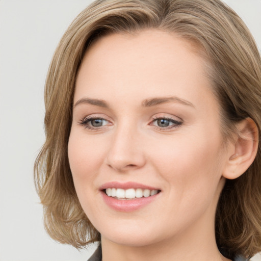 Joyful white young-adult female with long  brown hair and blue eyes