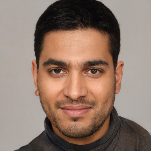 Joyful latino young-adult male with short  brown hair and brown eyes