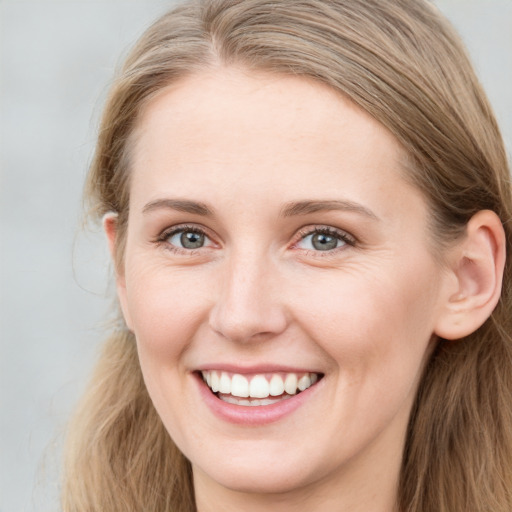 Joyful white young-adult female with long  brown hair and blue eyes