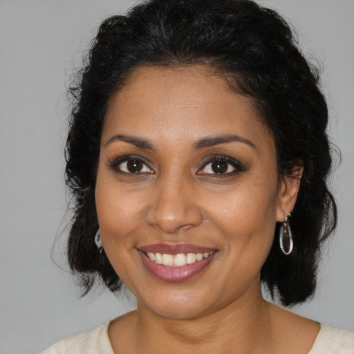 Joyful black young-adult female with medium  brown hair and brown eyes