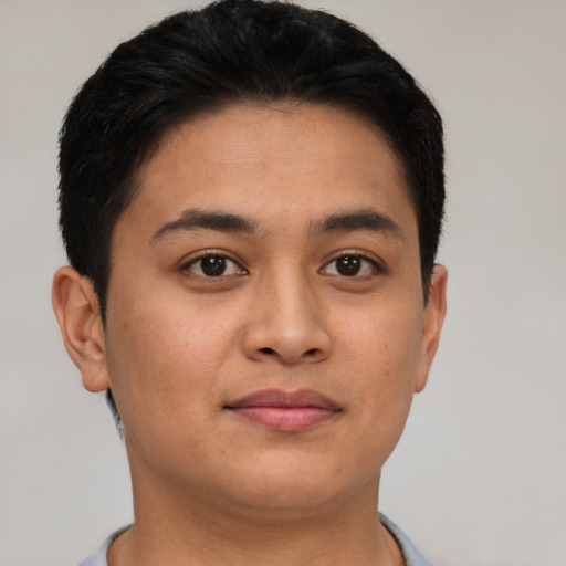Joyful latino young-adult male with short  brown hair and brown eyes