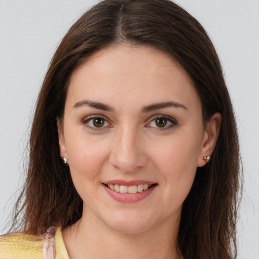 Joyful white young-adult female with long  brown hair and brown eyes