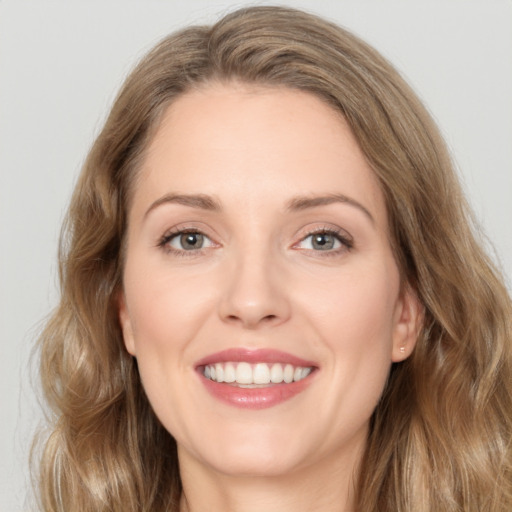 Joyful white young-adult female with long  brown hair and green eyes