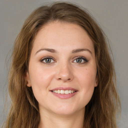 Joyful white young-adult female with long  brown hair and green eyes