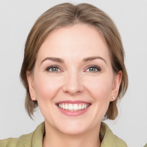 Joyful white young-adult female with medium  brown hair and green eyes