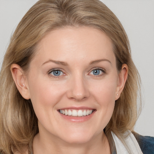 Joyful white adult female with medium  brown hair and blue eyes