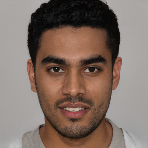 Joyful latino young-adult male with short  black hair and brown eyes