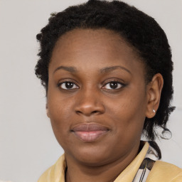 Joyful black young-adult female with long  brown hair and brown eyes