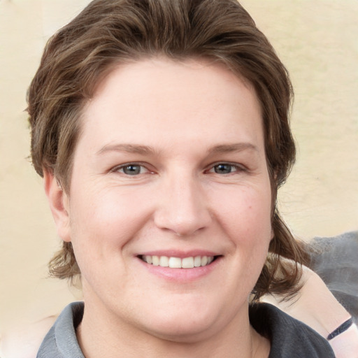 Joyful white young-adult female with medium  brown hair and grey eyes