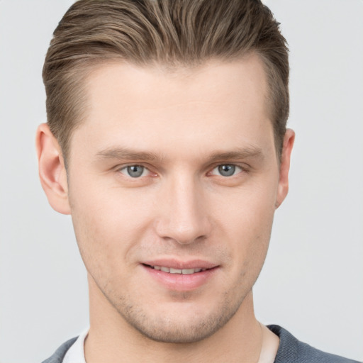 Joyful white young-adult male with short  brown hair and grey eyes