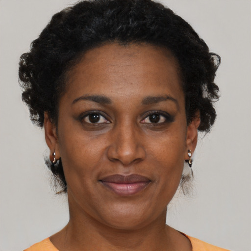 Joyful black adult female with short  black hair and brown eyes