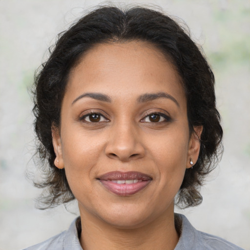 Joyful latino adult female with medium  brown hair and brown eyes