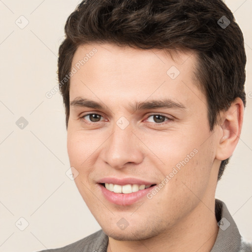 Joyful white young-adult male with short  brown hair and brown eyes