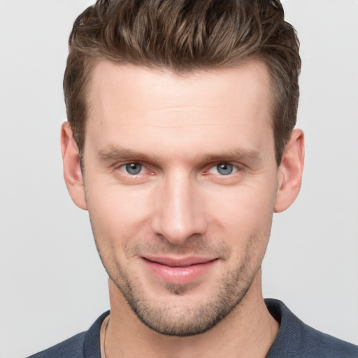 Joyful white young-adult male with short  brown hair and grey eyes