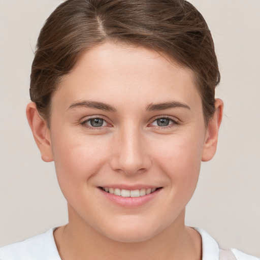 Joyful white young-adult female with short  brown hair and grey eyes