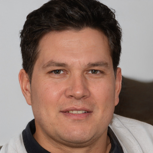 Joyful white adult male with short  brown hair and brown eyes