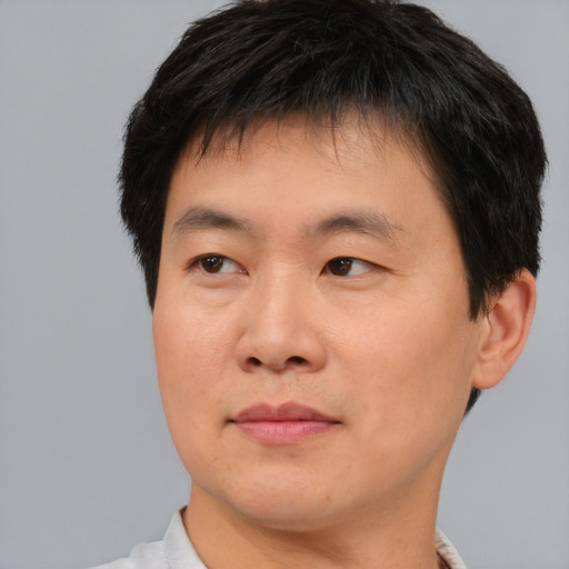 Joyful asian young-adult male with short  brown hair and brown eyes