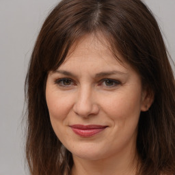 Joyful white adult female with long  brown hair and brown eyes