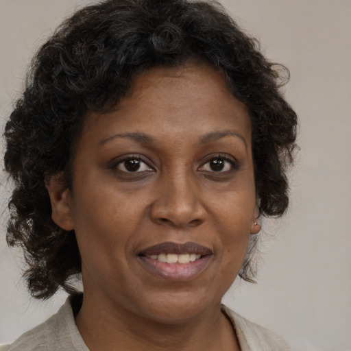 Joyful black adult female with medium  brown hair and brown eyes