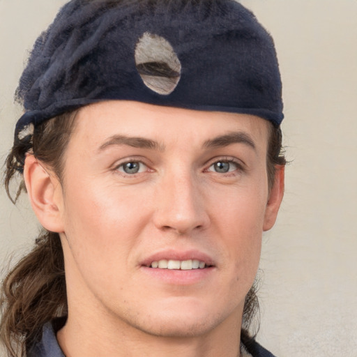 Joyful white young-adult male with medium  brown hair and grey eyes