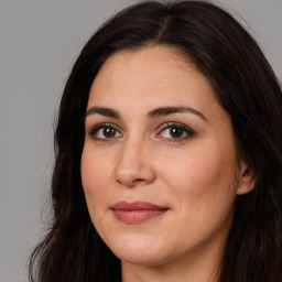 Joyful white adult female with long  brown hair and brown eyes