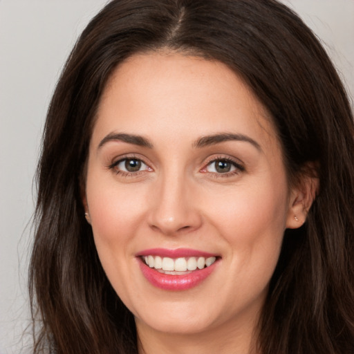 Joyful white young-adult female with long  brown hair and brown eyes