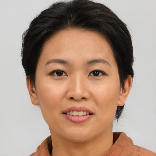 Joyful asian adult female with short  brown hair and brown eyes