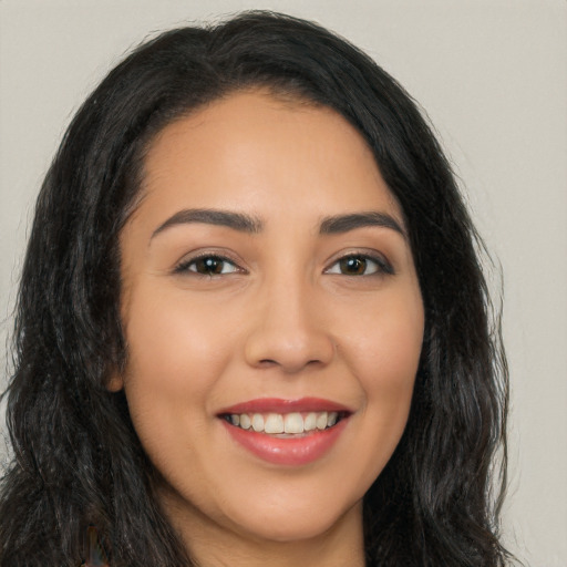 Joyful latino young-adult female with long  brown hair and brown eyes