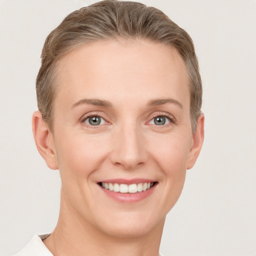 Joyful white young-adult female with short  brown hair and grey eyes