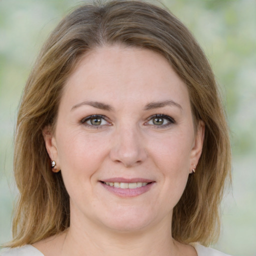 Joyful white young-adult female with medium  brown hair and green eyes