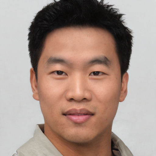 Joyful asian young-adult male with short  black hair and brown eyes