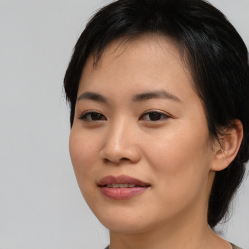 Joyful asian young-adult female with medium  black hair and brown eyes