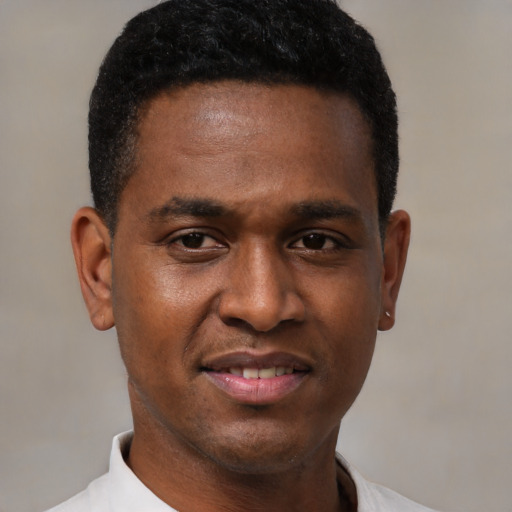 Joyful black young-adult male with short  black hair and brown eyes