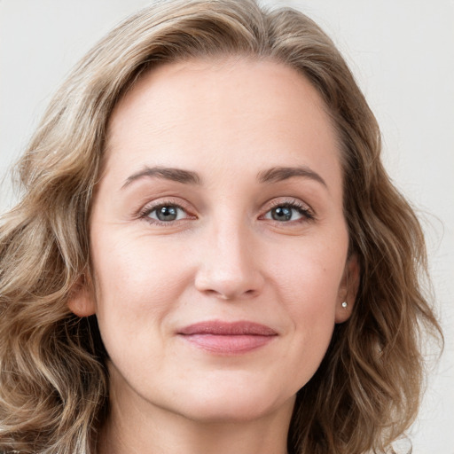 Joyful white young-adult female with long  brown hair and blue eyes