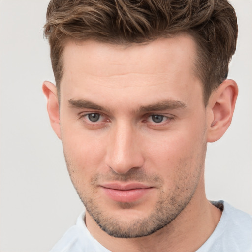 Joyful white young-adult male with short  brown hair and grey eyes