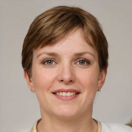 Joyful white young-adult female with short  brown hair and grey eyes