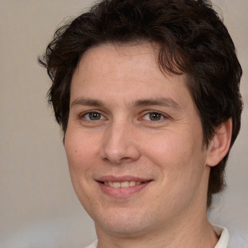 Joyful white adult male with medium  brown hair and brown eyes