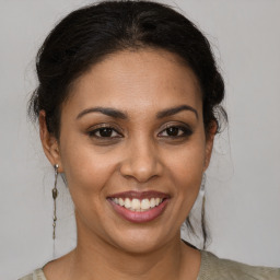 Joyful latino young-adult female with medium  brown hair and brown eyes