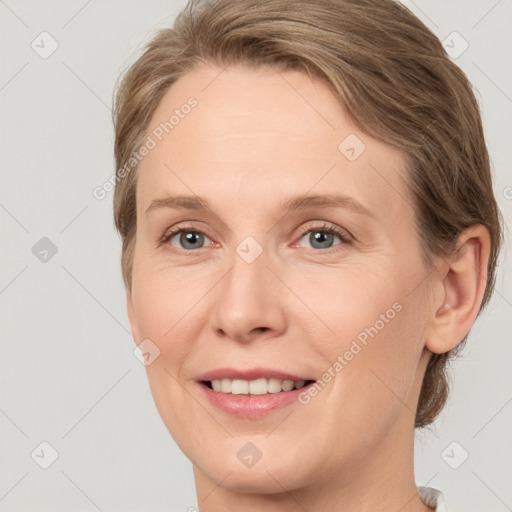 Joyful white adult female with medium  brown hair and grey eyes