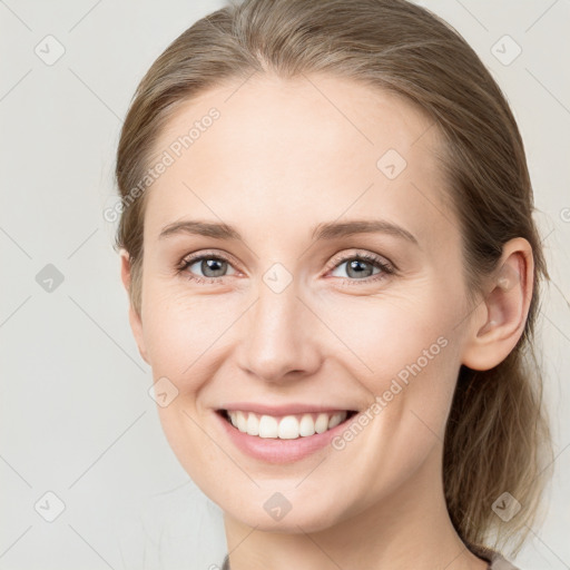 Joyful white young-adult female with medium  brown hair and grey eyes