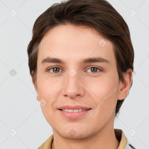 Joyful white young-adult male with short  brown hair and grey eyes